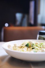 alfredo spaghetti broccoli chicken white sauce in restaurant background