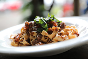 Pasta Fettuccine Bolognese with beef and tomato sauce on wood background in dark tone mystic light style