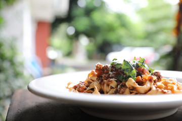 Pasta Fettuccine Bolognese with beef and tomato sauce on wood background in dark tone mystic light style