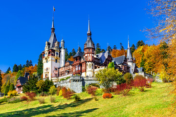 Fototapeta na wymiar Peles Castle, Sinaia, Prahova County, Romania: Famous Neo-Renaissance castle in autumn colours, at the base of the Carpathian Mountains, Europe