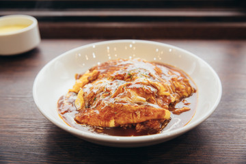 Curry rice with omelette Japanese style on wood background film vintage style