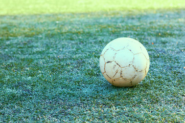 Old soccer ball on the grass.