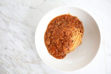 spaghetti Bolognese with minced beef and tomato sauce garnished with parmesan cheese and basil , Italian food