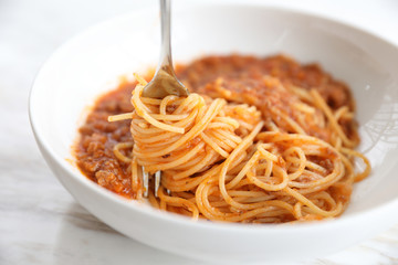 spaghetti Bolognese with minced beef and tomato sauce garnished with parmesan cheese and basil , Italian food