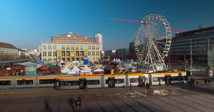 Leipziger Eistraum. Germany's largest round ice rink in Leipzig in the afternoon with blue sky. Tram in the foreground. 4K Pan Right Aerial Drone Shot.