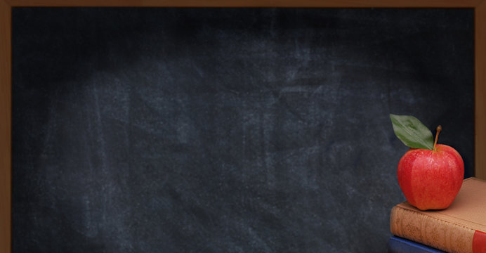 Text books with a red apple in front of a blank chalk board