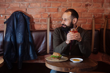 businessman male brunette beard glass hold cafe office house loft brave bearded hipster mulled wine close up hamburger