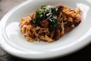 Pasta Fettuccine Bolognese with beef and tomato sauce on wood background in dark tone mystic light style