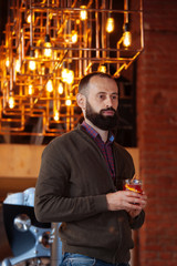 businessman male brunette beard glass hold cafe office house loft brave bearded hipster mulled wine