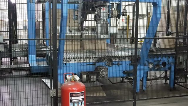 Feeding cardboard boxes of red wine to the palletizer machine