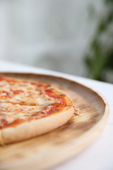 pizza margarita on wood dish in coffee shop background