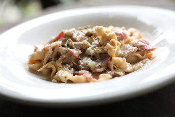 Pasta white sauce with bacon and mushroom on wood background in mystic light