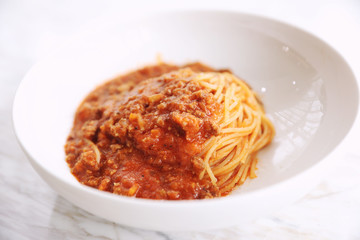 spaghetti Bolognese with minced beef and tomato sauce garnished with parmesan cheese and basil , Italian food