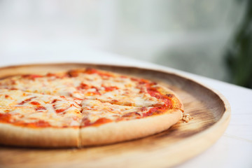 pizza margarita on wood dish in coffee shop background