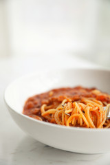 spaghetti Bolognese with minced beef and tomato sauce garnished with parmesan cheese and basil , Italian food