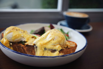 Egg benedict , poached eggs with toast and coffeeon wood background , English Breakfast