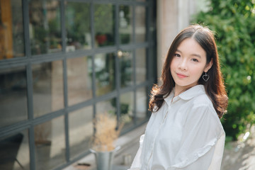 portrait of asian girl with white shirt and skirt looking in outdoor nature vintage film style