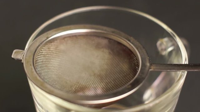 Person puts herbal tea in a strainer