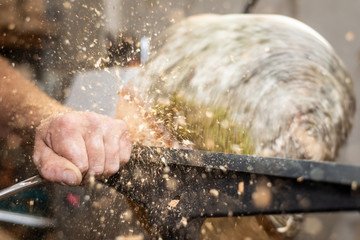 flying wooden sawdust shavings while creating timber bowl on turnery