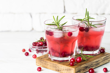 Cocktail with cranberry, vodka, rosemary and ice.