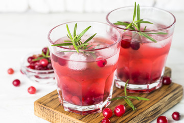 Cocktail with cranberry, vodka, rosemary and ice.