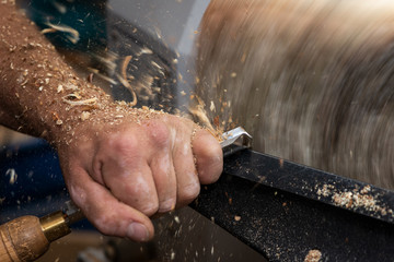wood in rotating motion while cutting and carving a timber bowl
