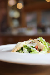 fresh salad with bacon and bread on wooden background