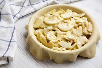 Preparation of apple pie on a white wooden background, side view. Close-up.