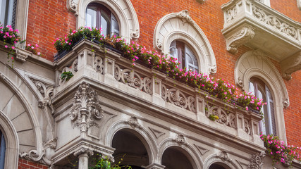 Fototapeta na wymiar houses with flowers on the windows in Milan, Italy