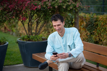 Obraz premium Handsome man using his mobile phone in a park