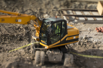 Tilt-shift capture of an excavator in a construction site.