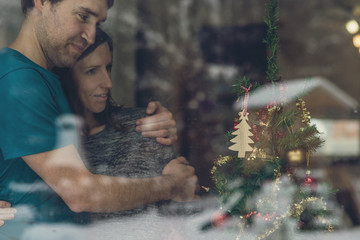 Couple standing next to a Christmas tree