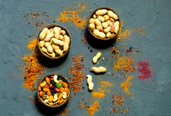 Peanuts in natural coconut bowls on the background of spices, the concept of a healthy, vegetarian food, close-up, copy space