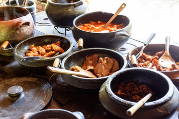 Traditional Brazilian food being prepared in clay pots and in the old and popular wood stove