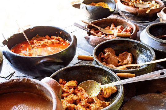 Traditional Brazilian food being prepared in clay pots and in the old and popular wood stove