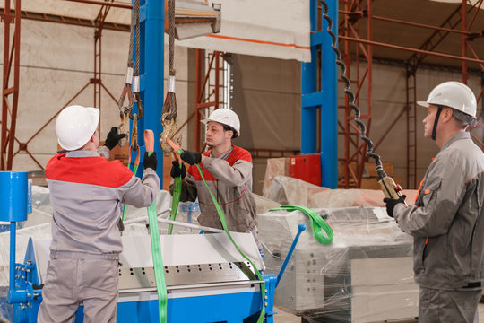 manufacture workshop. move the crane with beam. Workers adjusts the machine in the warehouse. the production of ventilation and gutters. Tool and bending equipment for sheet metal.