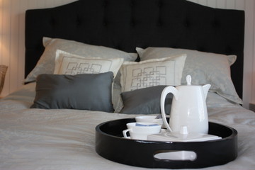 A coffee pot and cups on a tray ready for breakfast in bed.