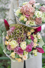 two beautiful spring bouquet. Young girl holding a flowers arrangements with various of colors. Bright dawn or sunset sun