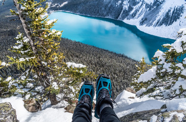 Winter boots hanging over blue glacial lake.