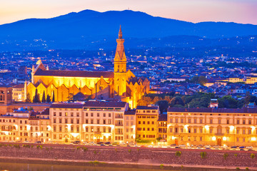 Arno river waterfront and illuminated church in Florence evening view