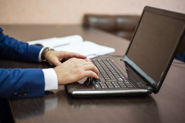 a man sitting at a laptop, a man typing on a laptop, a businessman at a laptop,.