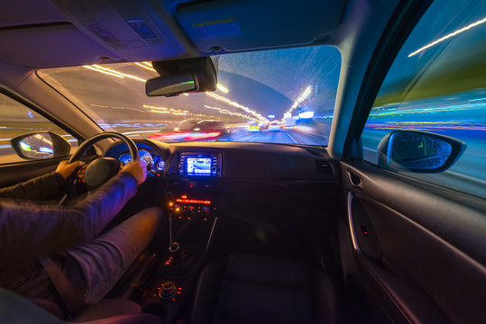 Driving in the night landscape, hands on the wheel. Raindrops.