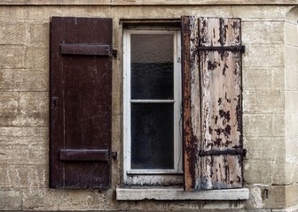 Fototapeta na wymiar Fenster mit halb geschlossenem Fensterladen andem der Lack abblättert