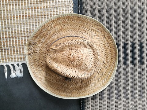Strohhut in Beige auf  Teppich aus Naturfaser in Pastellfarben auf grauem Betonboden im Wohnzimmer des Landhaus in Rudersau bei Rottenbuch im Pfaffenwinkel im Kreis Weilheim-Schongau in Oberbayern
