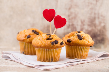 Homemade chocolate muffins with heart, vintage background.