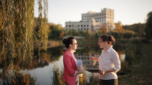 Two women are managers of construction companies to discuss the technical aspects, as well as inciting the estimate according to the technical documentation.
