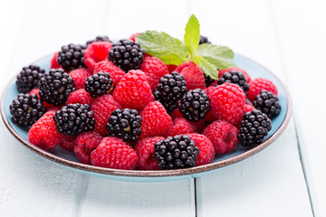 Fresh raspberries in a plate on a  vintage background.