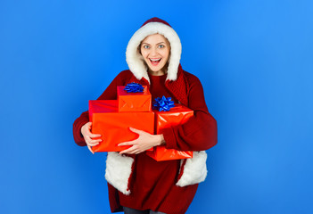 Beautiful happy girl in Santa hat with Christmas gifts boxes. Woman with christmas gifts. Shopping mall. Christmas shopping idea concept. Girl with gifts for new year. Girl in winter. Christmas sales.