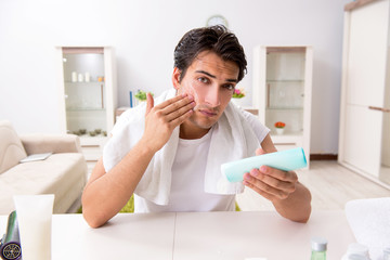 Young handsome man in the bathroom in hygiene concept 