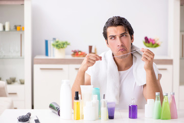 Young handsome man in the bathroom in hygiene concept 